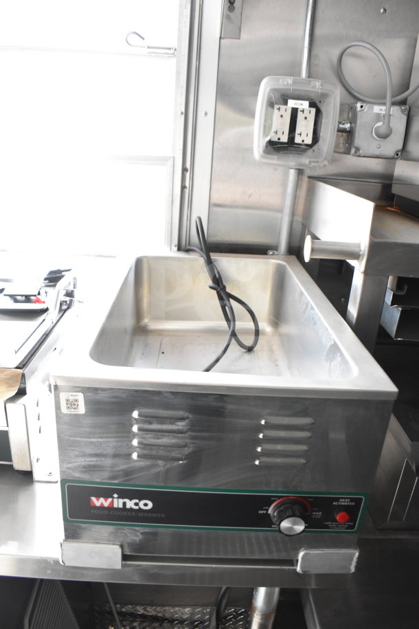Stainless steel Winco food cooker/warmer with adjustable temperature dial and power indicator, inside a commercial food trailer.