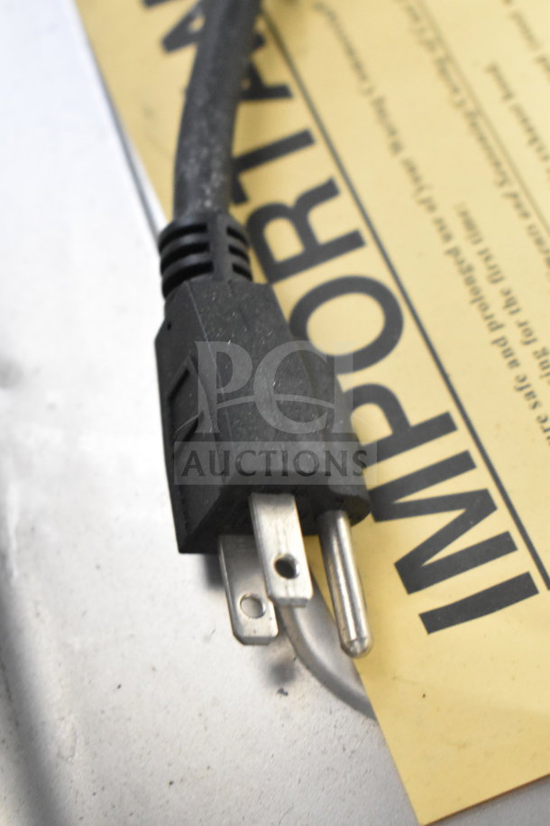 Close-up of a standard three-prong power plug resting on a yellow sheet marked "IMPORTANT."