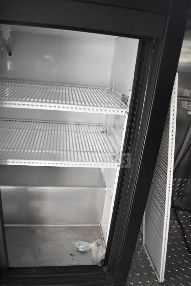 Interior view of a refrigeration unit inside a 2021 Rock Solid Cargo 28ft commercial food trailer, featuring wire shelves and a clean finish.
