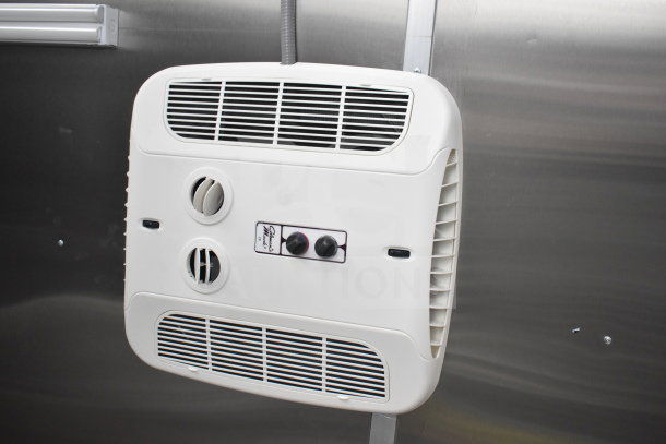 Wall-mounted ventilation system in a Rock Solid Cargo 28ft food trailer, featuring adjustable vents and control knobs.