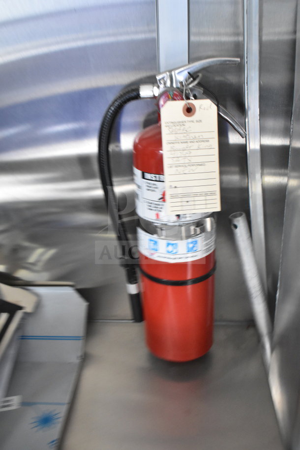 Red fire extinguisher inside the 2021 Rock Solid Cargo food trailer. Visible inspection tag noted.