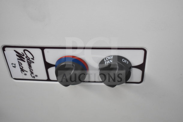 Coleman Mach 482 thermostat close-up showing two control knobs with temperature and fan settings.