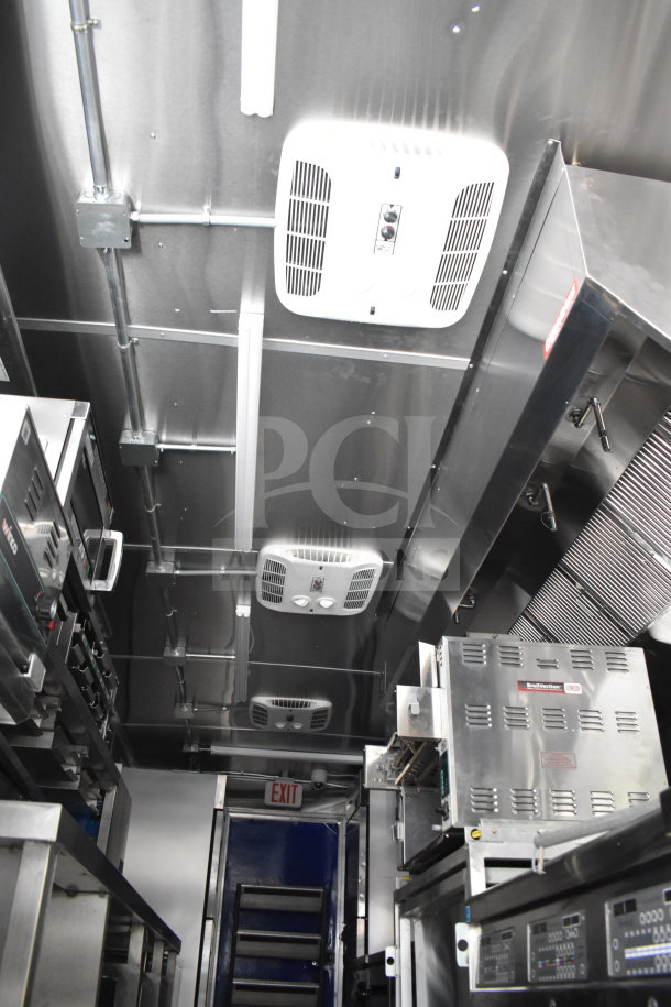 Interior of a 2021 Rock Solid Cargo 28ft food trailer, featuring a CaptiveAire hood system, refrigeration units, and a Nieco charbroiler.