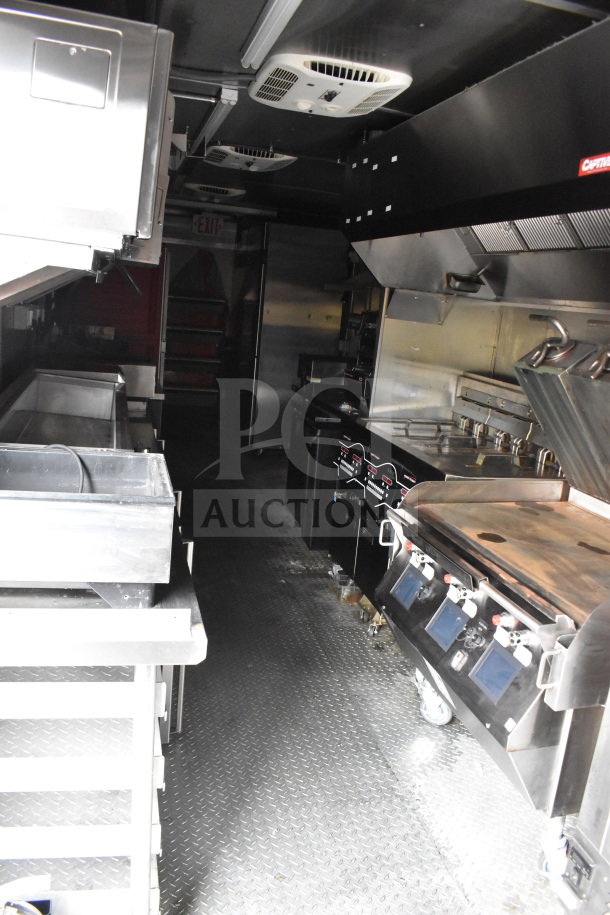 Interior of a 2021 Rock Solid Cargo 28ft food trailer featuring Henny Penny fryer, Taylor griddle, CaptiveAire hood, full refrigeration.