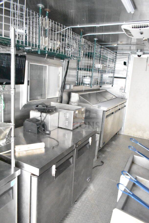 NBRHD Kitchens food trailer interior with dual Pitco gas fryers, CaptiveAire hood, Arctic Air refrigeration, and Daikin mini-split system.