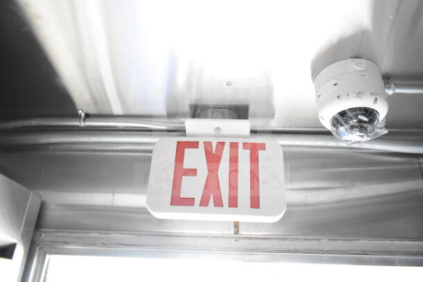 Interior of a Rock Solid Cargo food trailer featuring an EXIT sign and smoke detector on a stainless steel ceiling.