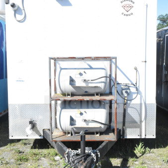 2021 Diamond Cargo 8.5'x24' food trailer in white, featuring dual propane tanks and hitch; logo visible, in good condition.