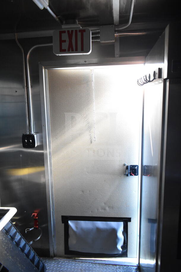 Exit door of a 2021 Diamond Cargo 8.5'x24' food trailer, featuring metallic interior and electrical wiring.