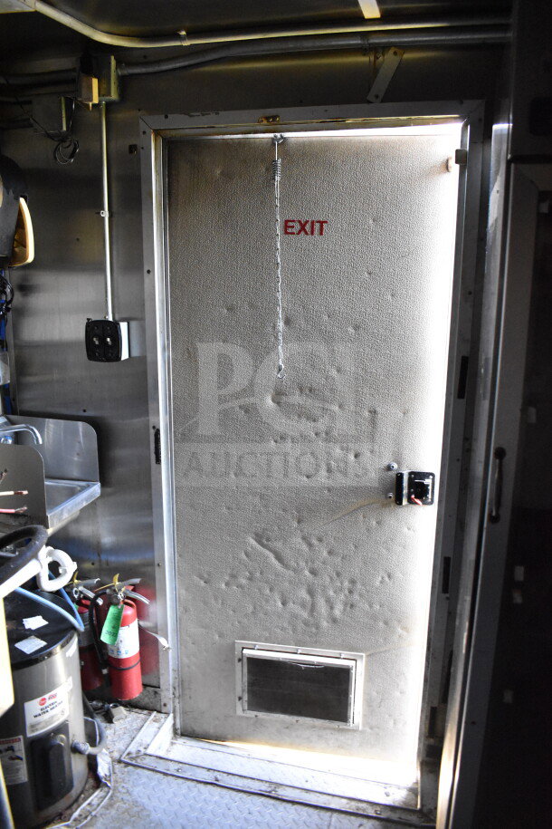 2019 Diamond Cargo 8.5'x24' food trailer interior exit door, showing fire extinguishers and equipment setup.