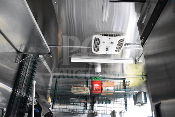 2021 Cruising Kitchens 8.5'x24' food trailer interior with CaptiveAire grease hood, shelving, and storage.