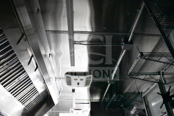 2021 Cruising Kitchens food trailer interior with CaptiveAire grease hood, suppression system, shelving, and ventilation.