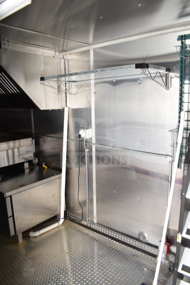 2021 Cruising Kitchens 8.5'x24' food trailer interior, featuring a CaptiveAire grease hood, suppression system, and stainless steel surfaces.