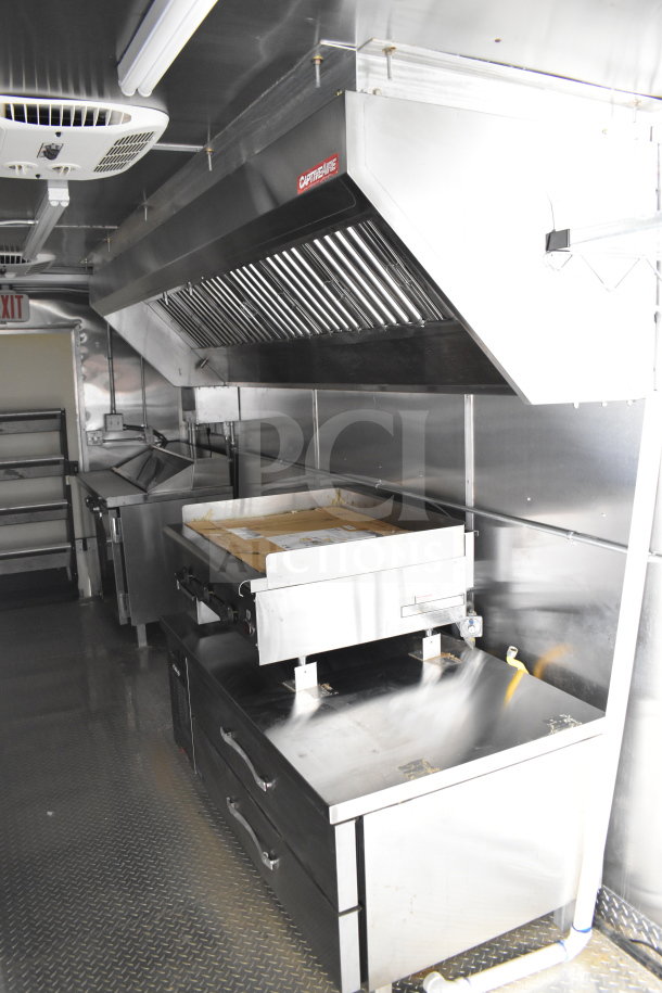 2021 Cruising Kitchens 8.5'x24' food trailer interior with CaptiveAire grease hood, suppression system, griddle, and refrigeration.