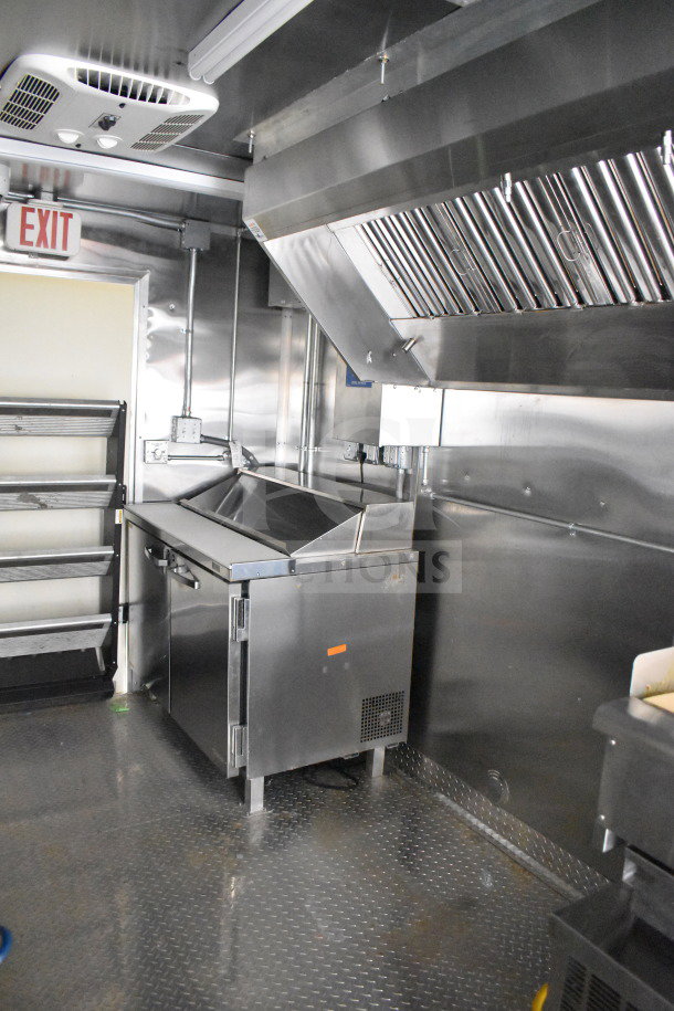 2021 Cruising Kitchens 8.5'x24' food trailer interior with CaptiveAire hood, suppression system, refrigeration, and griddle.