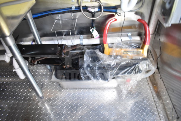 Inside view of 2021 Cruising Kitchens food trailer showing installed equipment and metal flooring.