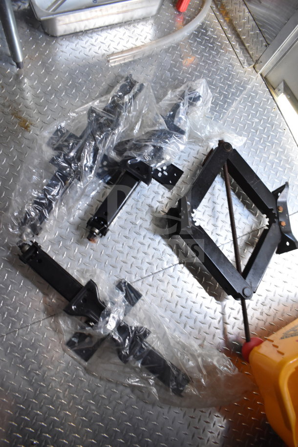 Components and tools on diamond plate flooring inside a 2021 Cruising Kitchens 8.5'x24' food trailer.