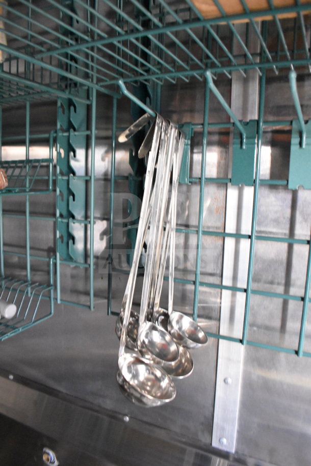 Hanging kitchen ladles in a Cruising Kitchens 2021 food trailer with metal shelving.