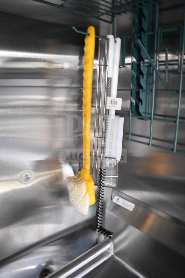 Interior of 2021 Cruising Kitchens food trailer showing cleaning tools and metal fixtures on stainless steel wall.
