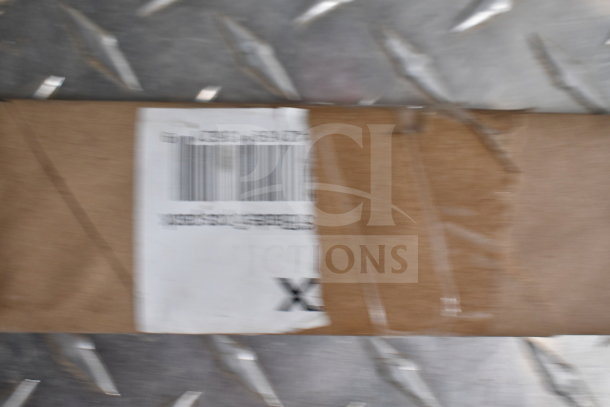 Blurred label on a cardboard box with barcode and text. Background shows diamond plate metal surface.