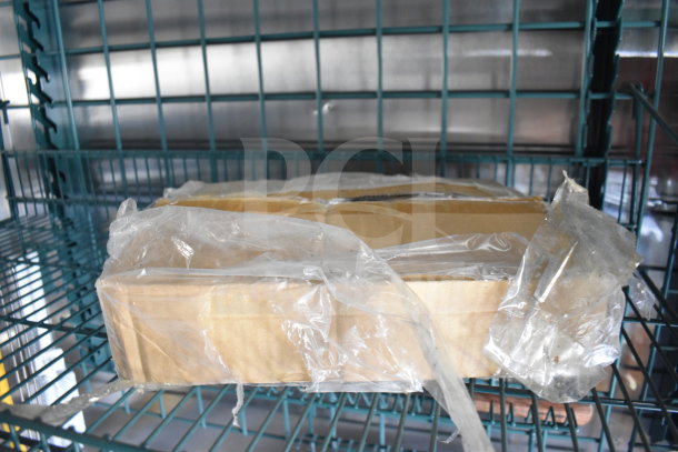 Image showing a cardboard box wrapped in plastic on a metal shelf inside a food trailer.