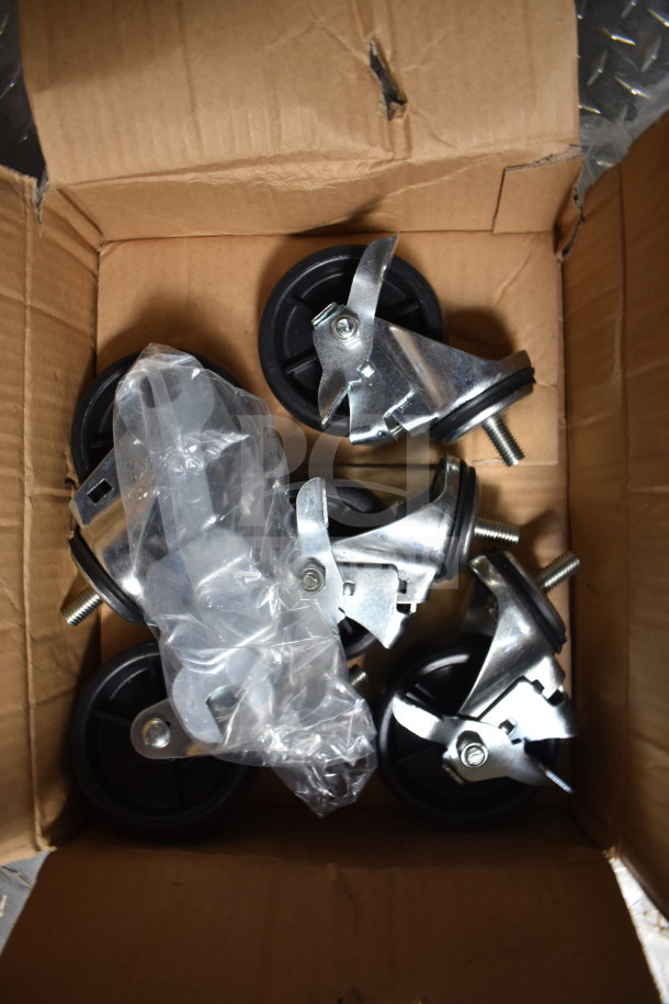 Box containing several metal caster wheels with black rubber bases, packaged with plastic wrap. Wheels appear new.