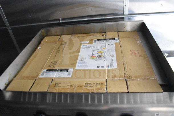 Interior view of a 2021 Cruising Kitchens food trailer, featuring installed equipment boxes. Labels and instructions visible on boxes.