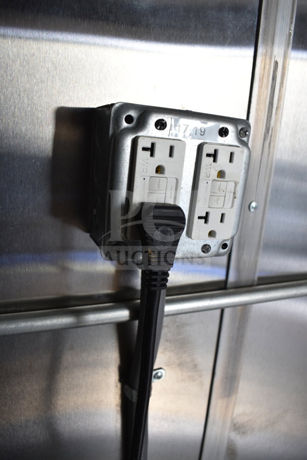 Electrical outlet in 2021 Cruising Kitchens food trailer showing a GFCI plug in stainless steel panel.