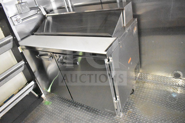 2021 Cruising Kitchens food trailer interior, featuring stainless steel refrigeration unit and griddle, in excellent condition.