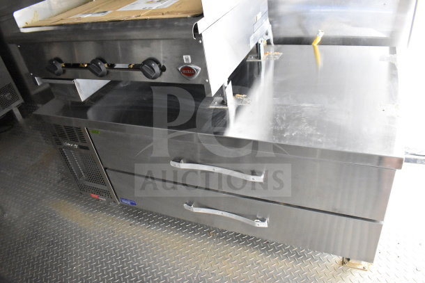 2021 Cruising Kitchens food trailer interior with griddle, refrigeration, and storage drawers; steel finish displays new condition.
