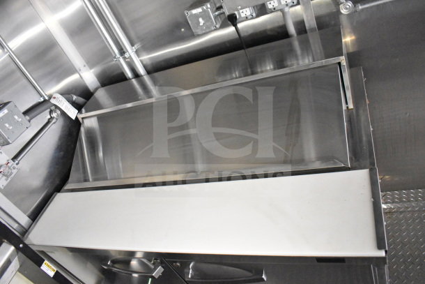 2021 Cruising Kitchens food trailer interior with stainless steel surfaces, CaptiveAire grease hood, and suppression system.