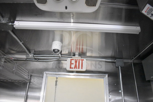 Interior of 2021 Cruising Kitchens food trailer with exit sign, ventilation, and lighting. Clean and well-maintained.