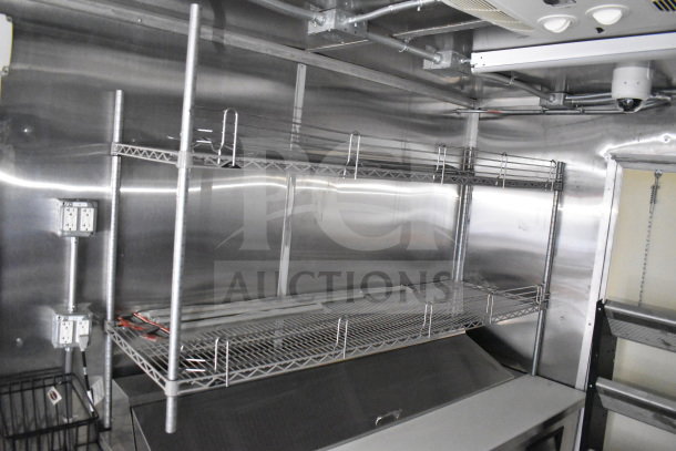 2021 Cruising Kitchens 8.5'x24' food trailer interior with stainless steel shelving, electrical outlets, and ventilation system.
