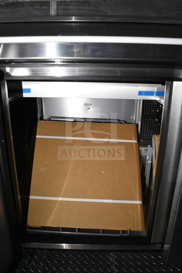 2021 Cruising Kitchens food trailer interior with refrigeration unit, CaptiveAire grease hood, and griddle.