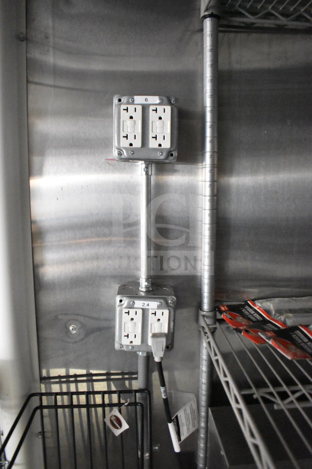 2021 Cruising Kitchens food trailer interior showing outlets, stainless steel surfaces, and shelving.
