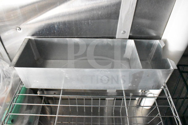 Metal grease catchment box on a wire rack inside the 2021 Cruising Kitchens food trailer, part of the CaptiveAire system.