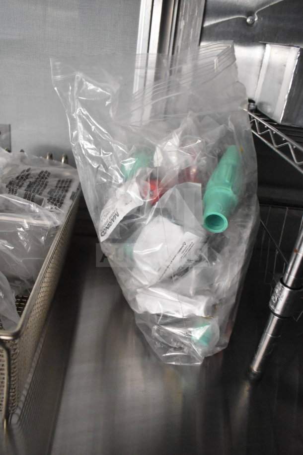 Bag of assorted plastic parts inside a 2021 Cruising Kitchens food trailer. Stainless steel surface and shelving nearby.