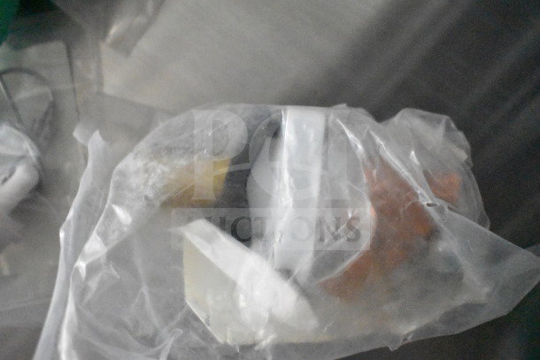 Plastic-wrapped items inside a transparent bag, indistinct due to packaging, possibly kitchen components or tools.