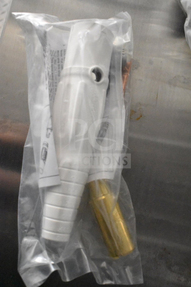 Packaging containing a white plastic nozzle and brass fitting, sealed with instructional paper visible.