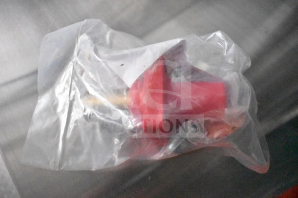 A small red plastic fitting in sealed packaging, possibly a part for a food trailer.