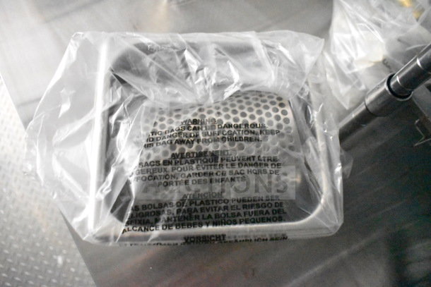 Plastic-wrapped perforated metal panel with safety warnings in multiple languages, part of the food trailer's equipment.