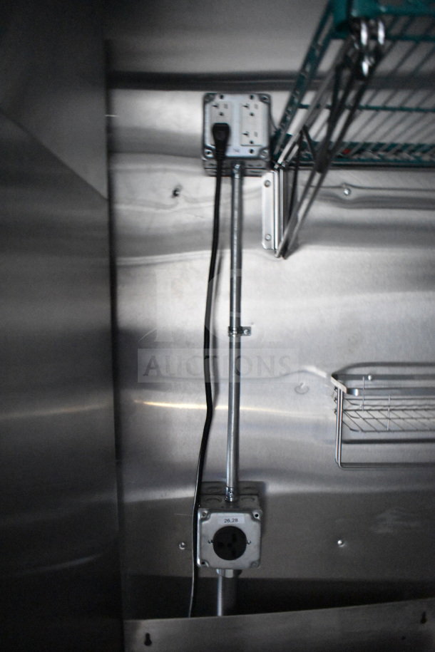 Interior view of a 2021 Cruising Kitchens food trailer featuring electrical outlets and metal shelving in an industrial setting.