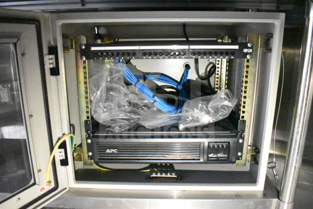 2021 Cruising Kitchens food trailer interior, featuring APC power supply, blue cables, and patch panel.