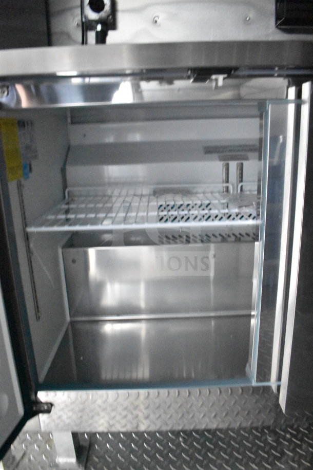 2021 Cruising Kitchens 8.5'x24' Food Trailer interior, features refrigeration unit with metal shelving and diamond plate flooring.