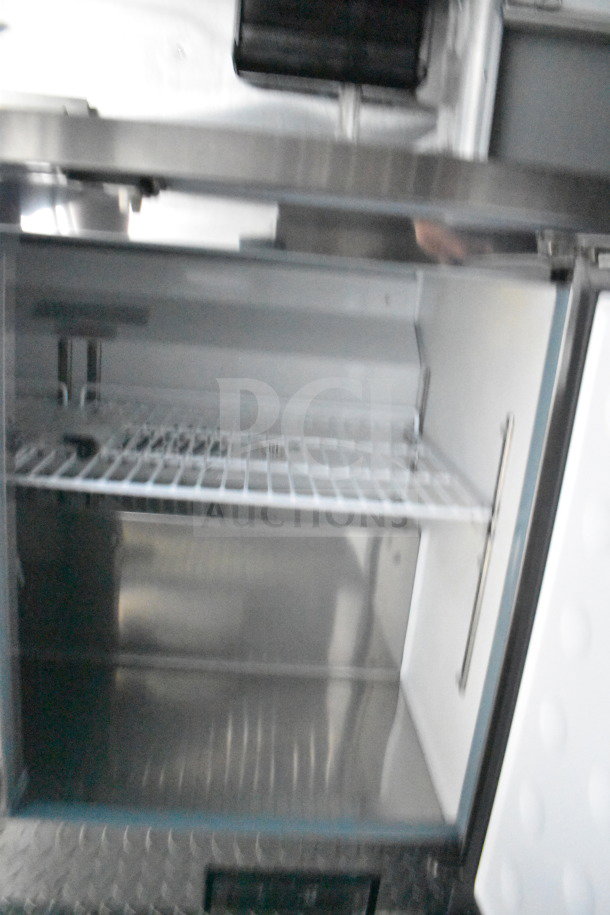 2021 Cruising Kitchens 8.5'x24' food trailer interior showing refrigeration unit, stainless steel shelving, and clean condition.