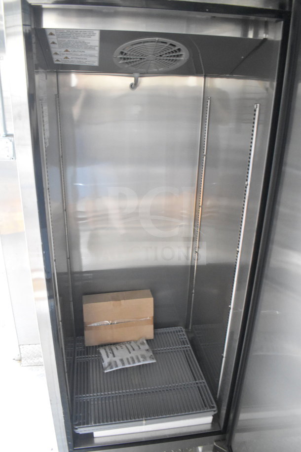 Interior view of a 2021 Cruising Kitchens food trailer's refrigeration unit, featuring wire shelves and a ventilation fan.