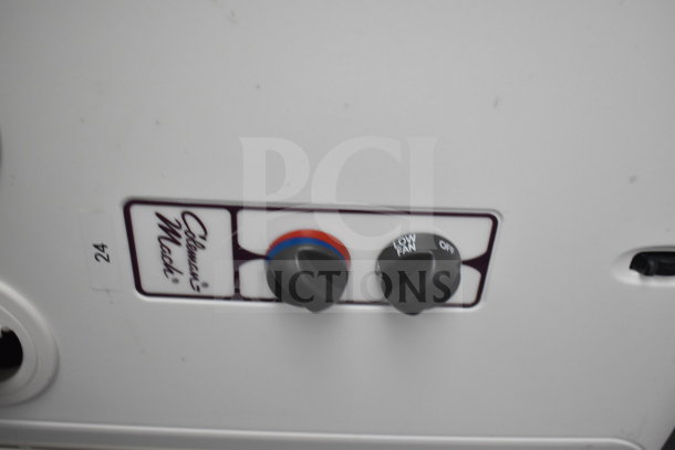 Close-up of Coleman Mach control knobs on a 2021 Cruising Kitchens food trailer, showing settings for temperature and fan speed.