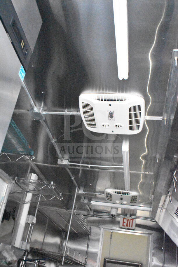 2021 Cruising Kitchens 8.5'x24' food trailer interior, featuring CaptiveAire grease hood, suppression system, shelving, and exit sign.