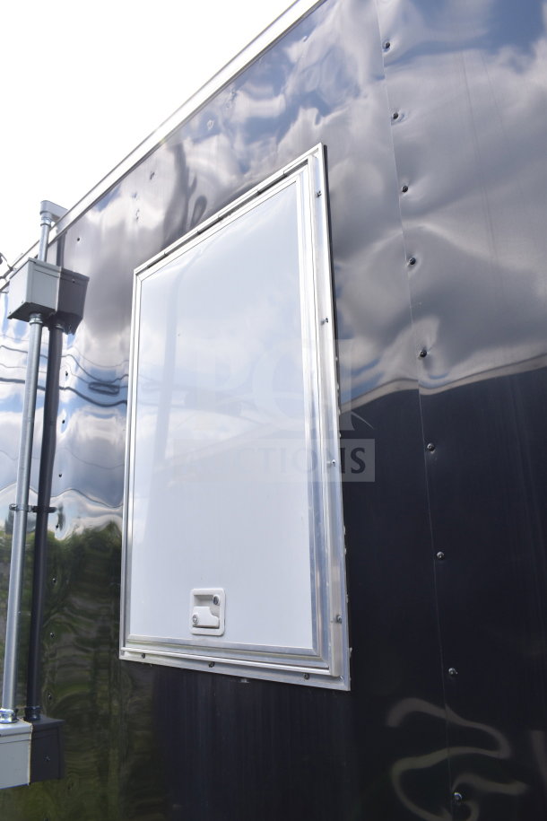 2021 Cruising Kitchens 8.5'x24' food trailer, black exterior, side view. Features include CaptiveAire grease hood.