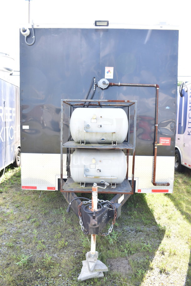 2021 Cruising Kitchens 8.5'x24' food trailer, two propane tanks, black exterior, VIN 7PLBC2429MM000193 displayed.