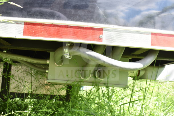 2021 Cruising Kitchens 8.5'x24' food trailer underside with hoses and reflective tape; VIN 7PLBC2429MM000193.